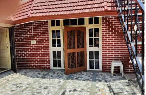 Mysore Apartment | Open front yard with mature trees for relaxation.