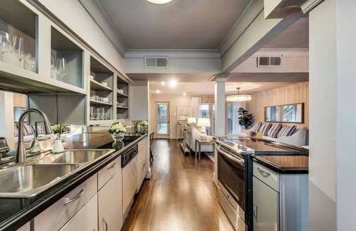 Lower Greenville Condo | Tailored for comfort and productivity, this two-bedroom executive condo features a full kitchen with premium appliances, an elegant dining room, and spacious living areas. Both bedrooms include plush king beds, full-size closets, and stylish dressers