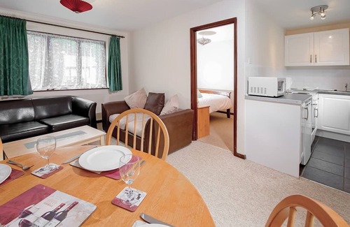 Chysauster Cottage | This silver cottage features an open kitchen, dining room, and living room.