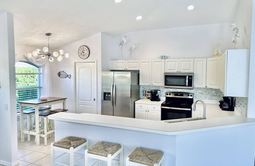 Central Naples House | Villa in gated community -Large South facing saltwater heated pool- lake views!