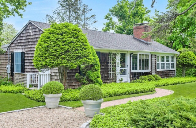 Beautiful cottage on meticulously maintained lawn, surrounded by.