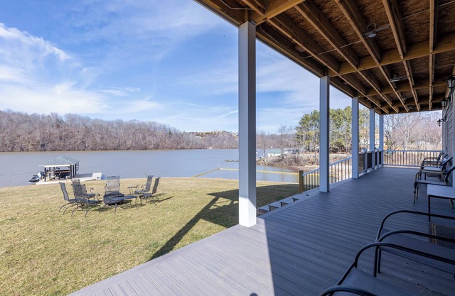 Modern lakefront home with wraparound decks, firepit, and stunning water views on both levels.
