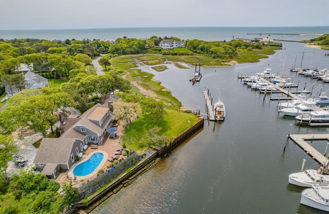 Nautical retreat with water views, inground heated pool, and private beach access