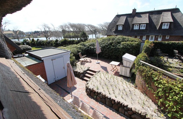 Thatched house in beach house style on the Wenningstedt village pond.