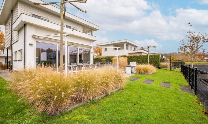 Zeewolde House | Luxurious 8-person houseboat with jacuzzi, sauna, 3 bedrooms, and garden by the water. Includes swim ladder, large dining table, sun loungers, and fully equipped kitchen. Located at Villa Resort Harderwold near the Veluwemeer!