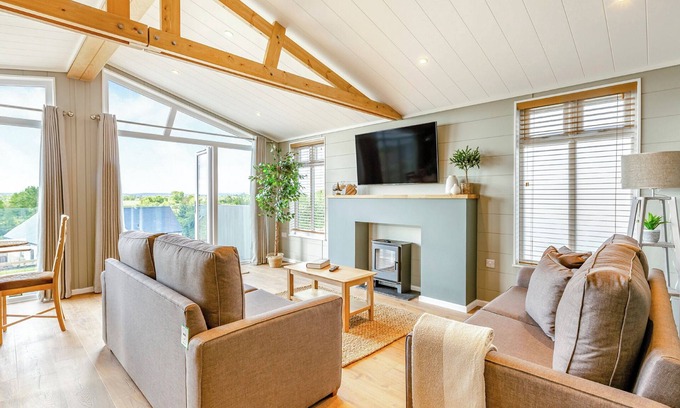 Middlezoy Ski Chalet | Luxurious lodge with vaulted ceilings and a welcoming feature fireplace.