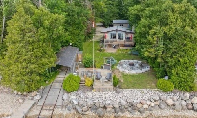 South Bruce Peninsula House | Relax at this waterfront cottage on Colpoy’s Bay—perfect for up to 6 adults and 2 kids. Enjoy a private dock with tiki bar, firepit by the lake, boat access, and nearby trails. A peaceful, fully equipped retreat for your next vacation getaway.