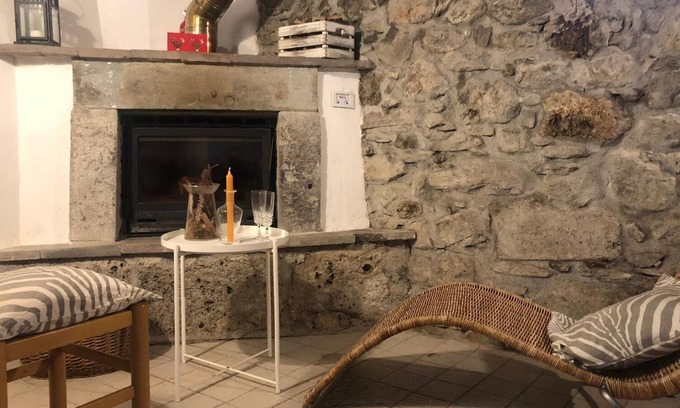 Raveo House | Rustic apartment with beams and stone.