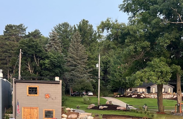 50 feet of Torch Lake frontage! Boathouse, beautiful patios sweet little beach.